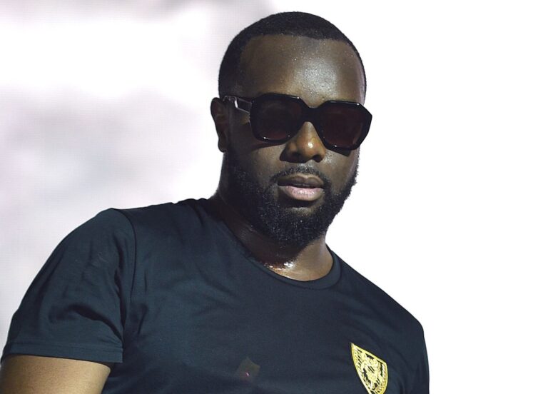 Maître Gims posant dans un décor luxueux, illustrant sa réussite financière