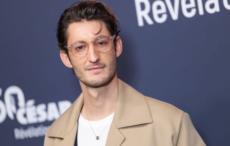 Pierre Niney en costume lors du photocall des révélations des César 2025 à Paris, symbole de son succès et de sa notoriété en 2024
